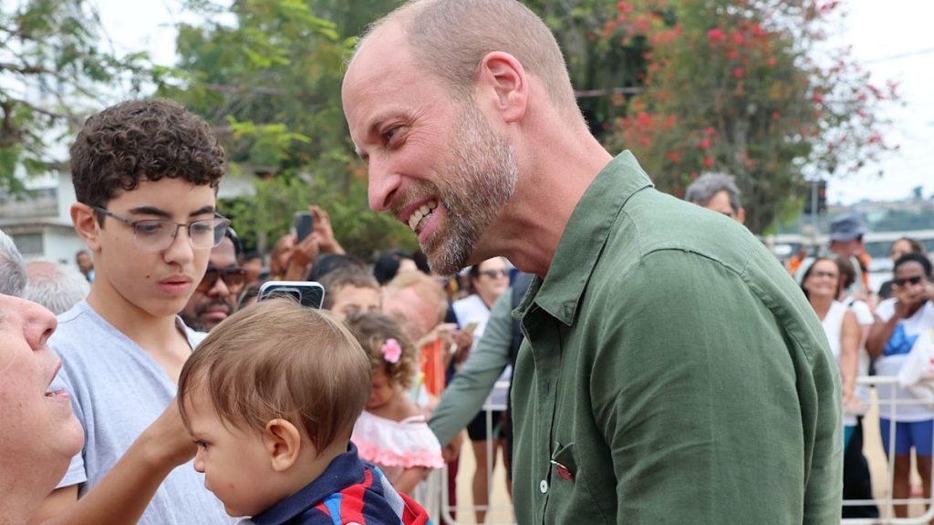 Prince William cuddles child in Brazil as he jokes ‘shouldn’t drop him!’